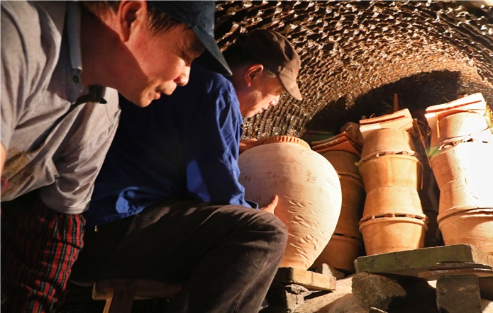 宜兴龙窑烧制技艺传承人吴永兵与窑工一起装窑。 