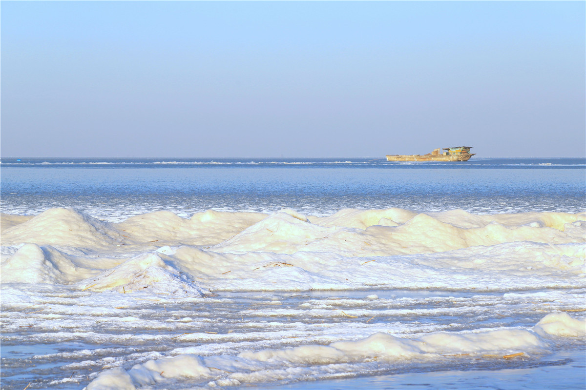 2021年1月14日，持续低温让江苏宿迁骆马湖出现少有的冰封现象。清澈的湖水结冰后在阳光的照耀下，呈现五彩斑斓之色，构成一幅美丽的冰雪画卷。