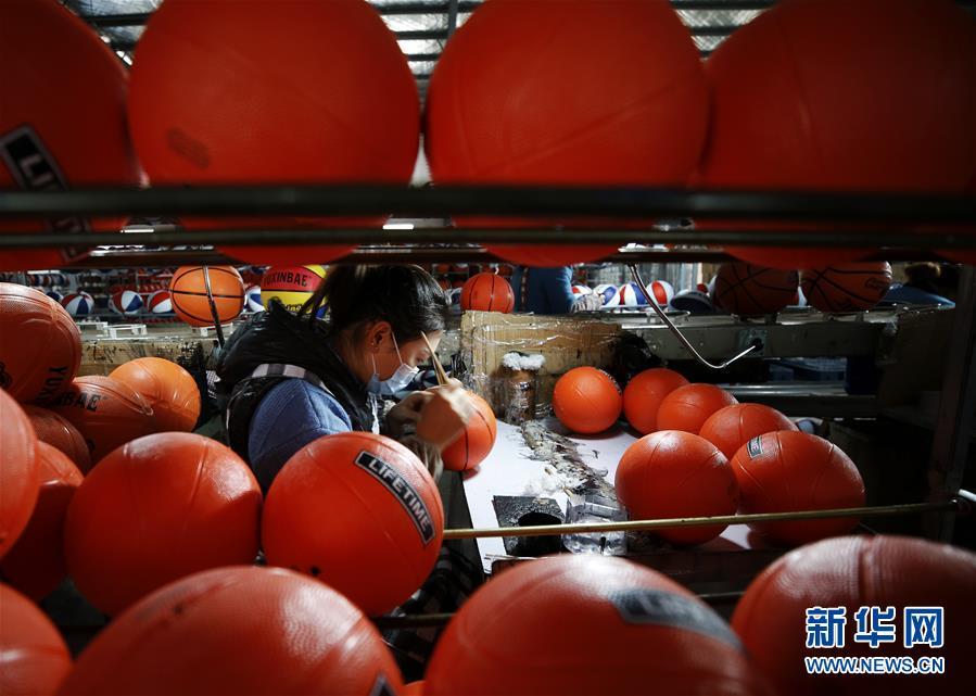 在泗洪经济开发区一制球企业，曾经在外打工的返乡农民王欣平在生产车间忙碌。新华社发（许昌亮 摄）