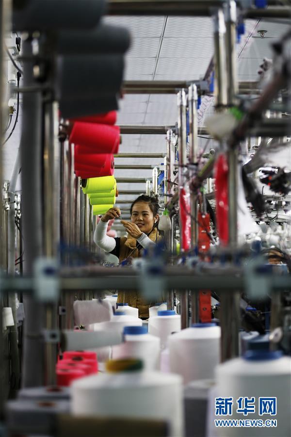 在泗洪经济开发区一纺织企业，曾经在外打工的返乡农民陈晓娟在生产车间忙碌。新华社发（许昌亮 摄）